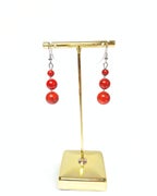 Nainen taitekohdassa helmikorvakorut, punainen