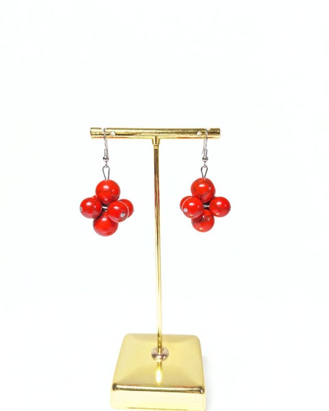 Nainen taitekohdassa helmikorvakorut, punainen monihelmi